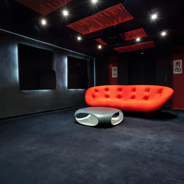 Красный диван в темной комнате — стоковое фото