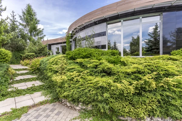 Futuristische vorm van residentiële gebouw badend in het groen — Stockfoto