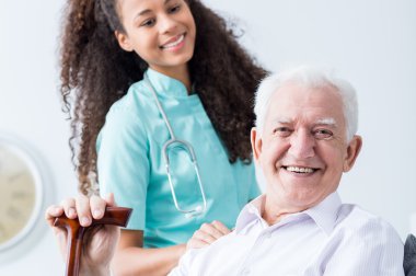Smiling old man and young caregiver clipart