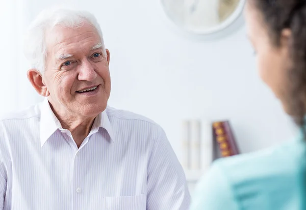 Senior man talking to caregiver — Stock Photo, Image