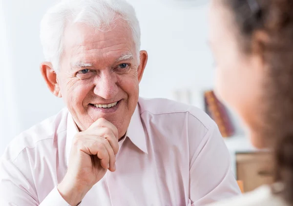 Senior man die lacht naar jonge vrouw — Stockfoto