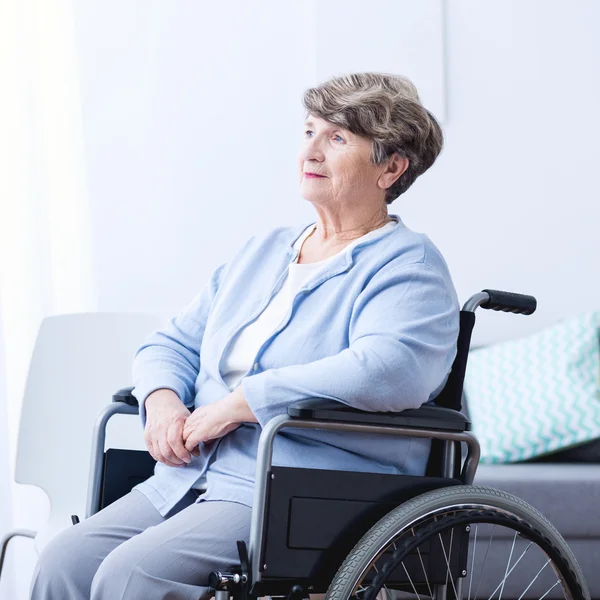 Инвалидная пожилая женщина в инвалидном кресле — стоковое фото