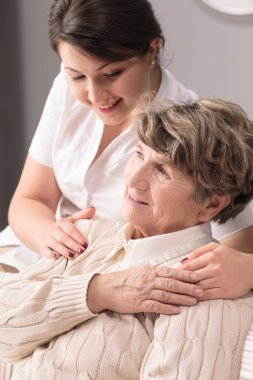 Genç kadın caregiver sarılma yaşlı kadın