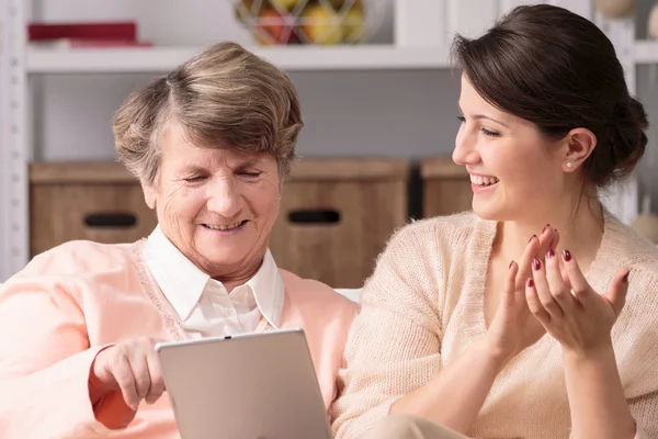 Donna anziana e badante femminile utilizzando tablet — Foto Stock