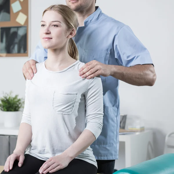 Fisioterapeuta que ayuda al paciente — Foto de Stock