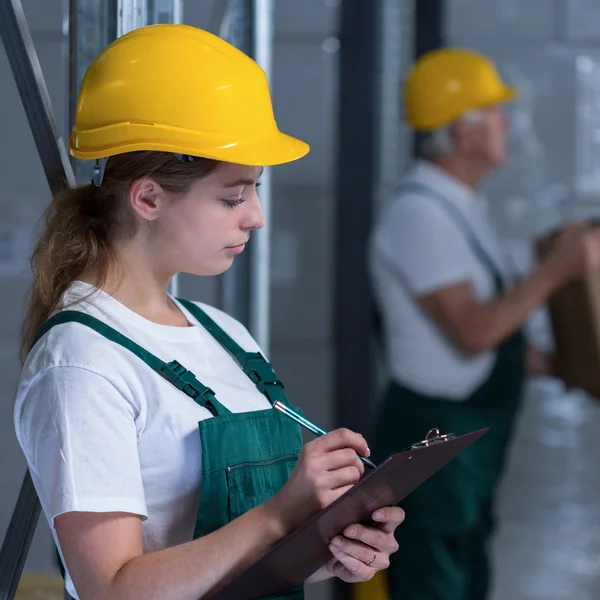 Trabajadora de fabricación femenina sujetando portapapeles — Foto de Stock