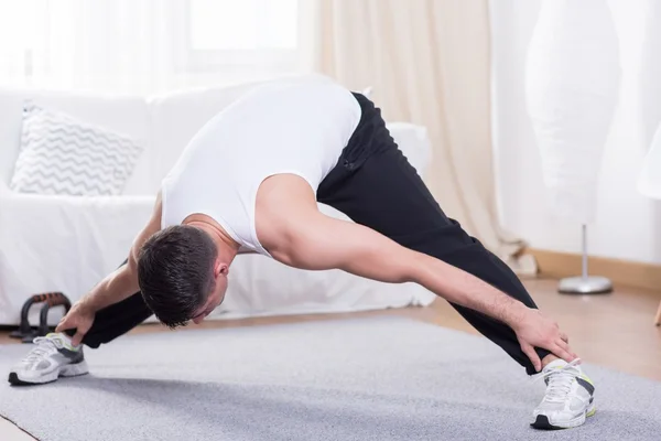 Jovem cara alongando seu corpo — Fotografia de Stock