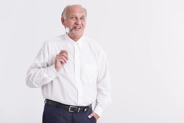 Senior man holding a paper pipe — Stock Photo, Image