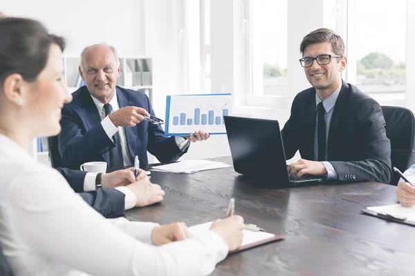 Positieve office vergadering aan een massieve tafel — Stockfoto