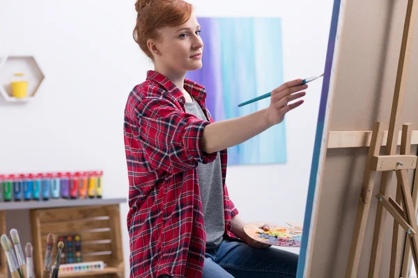 Jovem pintora no trabalho em seu estúdio — Fotografia de Stock