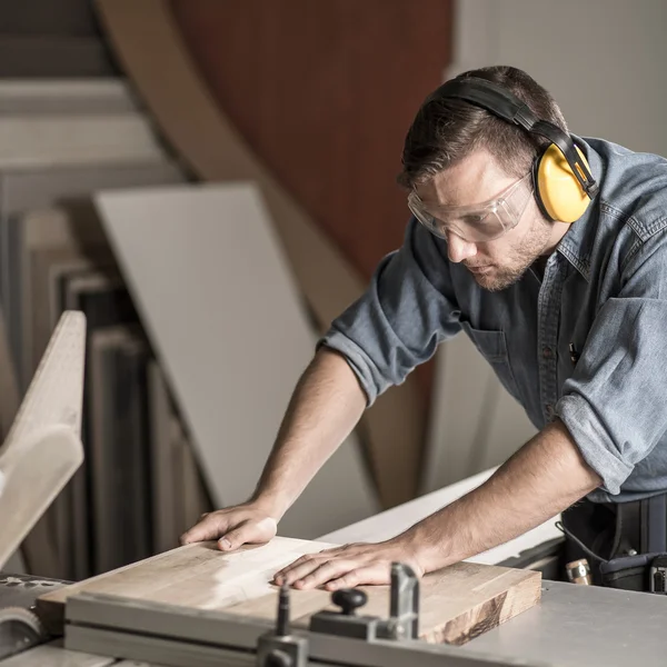Worker sawing board for furniture — Stock Photo, Image