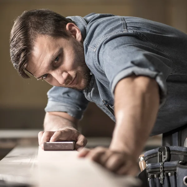 Joiner polishing wooden board — Stock Photo, Image