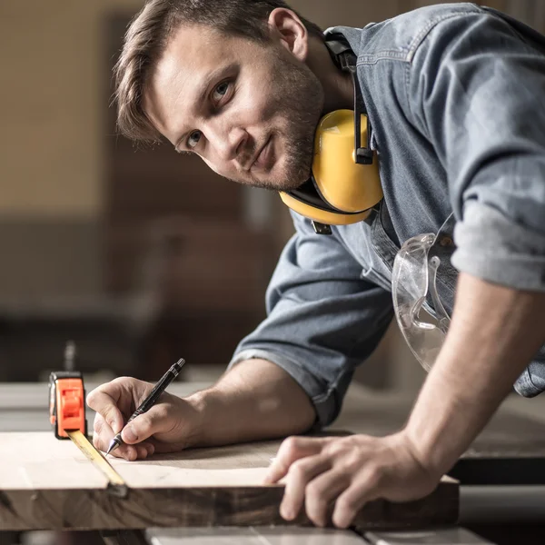 Tischler misst Holzbretter — Stockfoto