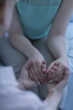 İki kadın ellerini tutuyor.