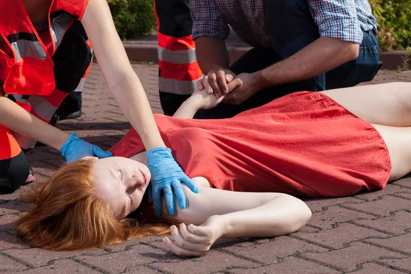 Paramedic helping unconscious woman — Stock Photo, Image