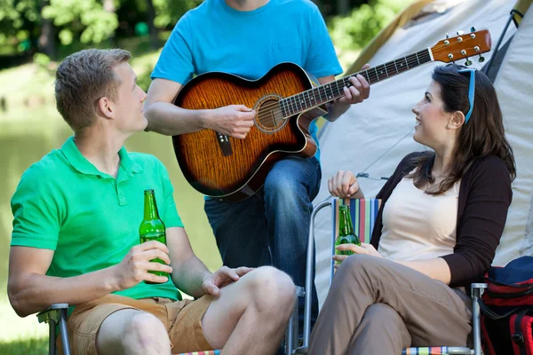 Pareja escuchando al hombre tocar la guitarra —  Fotos de Stock