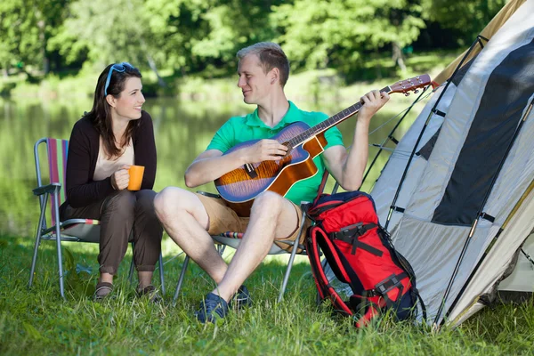 Kvinna och man camping över sjön — Stockfoto