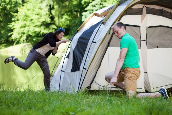 Coppia cercando di piantare una tenda — Foto Stock