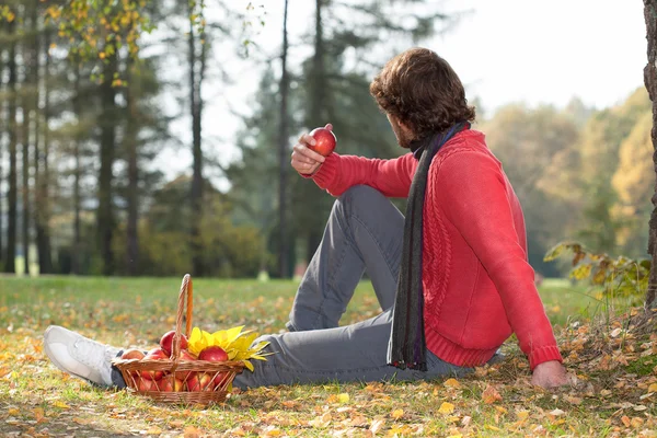 Man eating apple in the park — Stock Photo, Image