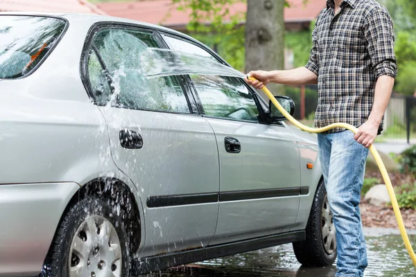 Homem enxaguando espuma de carro — Fotografia de Stock