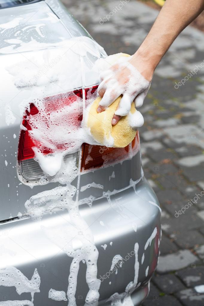 Man using foam for cleaning car