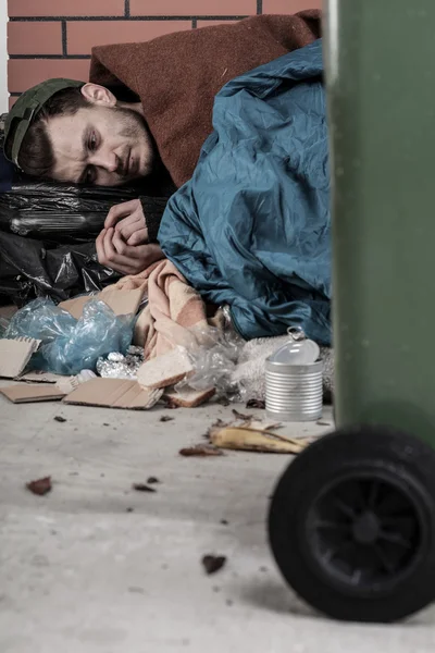 Бездомний чоловік лежить зі сміттям — стокове фото