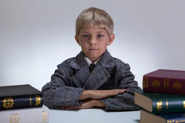 Kleiner Schüler unter Büchern — Stockfoto