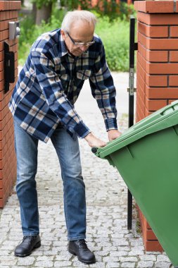 adam tekerlekli çekerek çöplüğü
