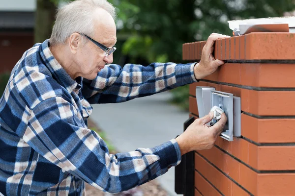 Man repairing intercom at the gate — Stock Photo, Image