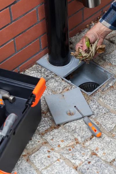 Elderly man cleans the gutter — Stock Photo, Image