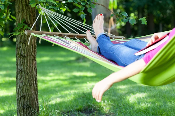 Dame liegt mit Buch auf Hängematte — Stockfoto