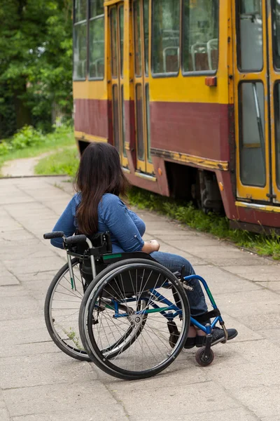 Menina deficiente à espera de um bonde — Fotografia de Stock