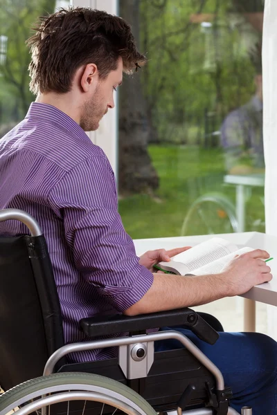 Uomo disabile che legge un libro a casa — Foto Stock