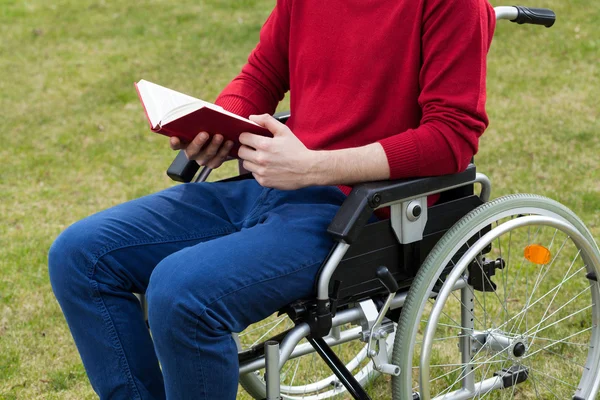 Hombre discapacitado leyendo libro en el jardín — Foto de Stock