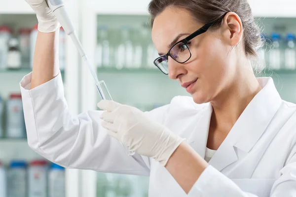 Wetenschapper met behulp van precisiepipet in laboratorium — Stockfoto