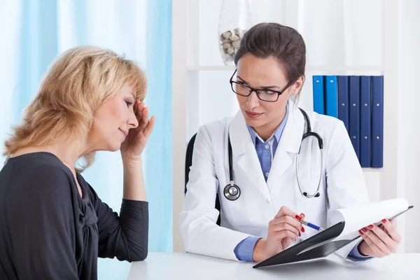 Mulher com enxaqueca no consultório médico — Fotografia de Stock