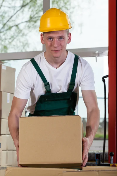 Portrait of a warehouse worker lifting a box — Stock Photo, Image