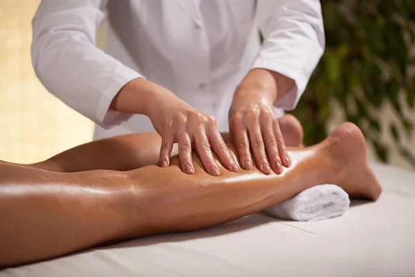 Hands massaging female calf — Stock Photo, Image