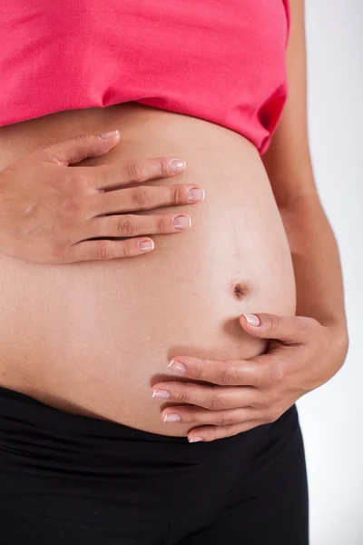 Zwangere vrouw verzorgen over haar buik — Stockfoto