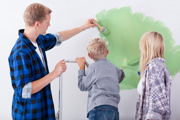 Family painting interior wall of home