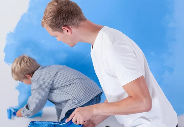 Padre mirando a su hijo durante la pintura mural — Foto de Stock