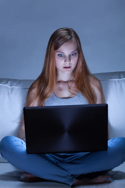 Νεαρή γυναίκα που χρησιμοποιεί φορητό υπολογιστή τη νύχτα — Φωτογραφία Αρχείου