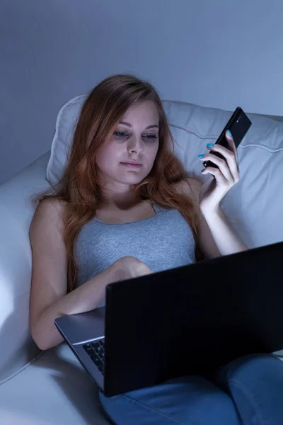 Muchacha aburrida usando teléfono y portátil —  Fotos de Stock