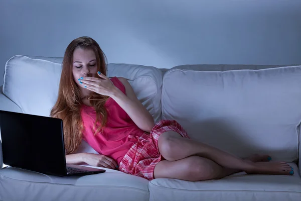 Menina sonolenta usando laptop à noite — Fotografia de Stock