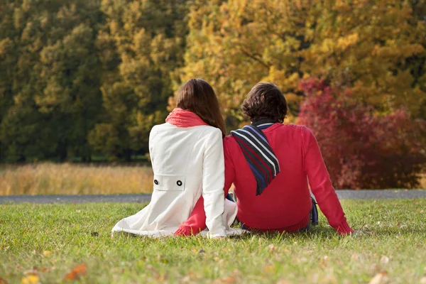 Couple sitting on the ground in the park — Stock Photo, Image