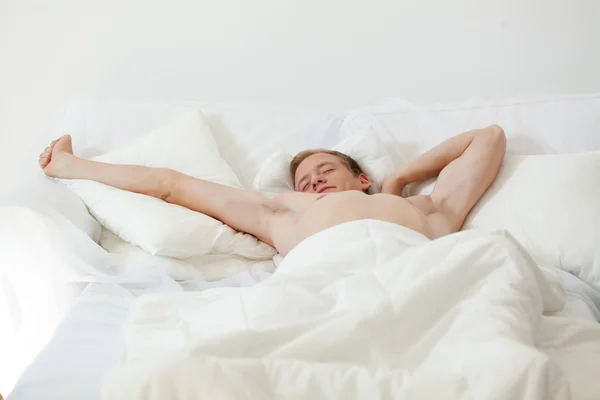 Single man waking up in bed — Stock Photo, Image