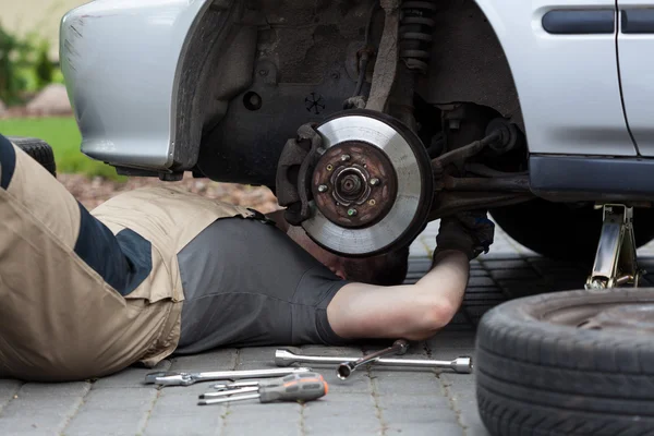 Mechanic repairing car wheel — Stock Photo, Image