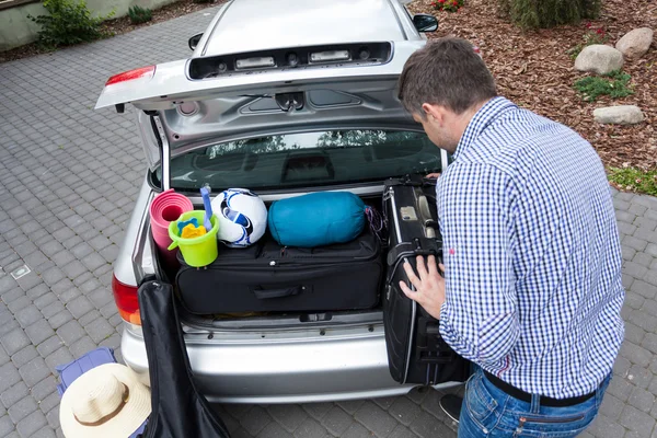 Papai preparando carro tronco para férias — Fotografia de Stock