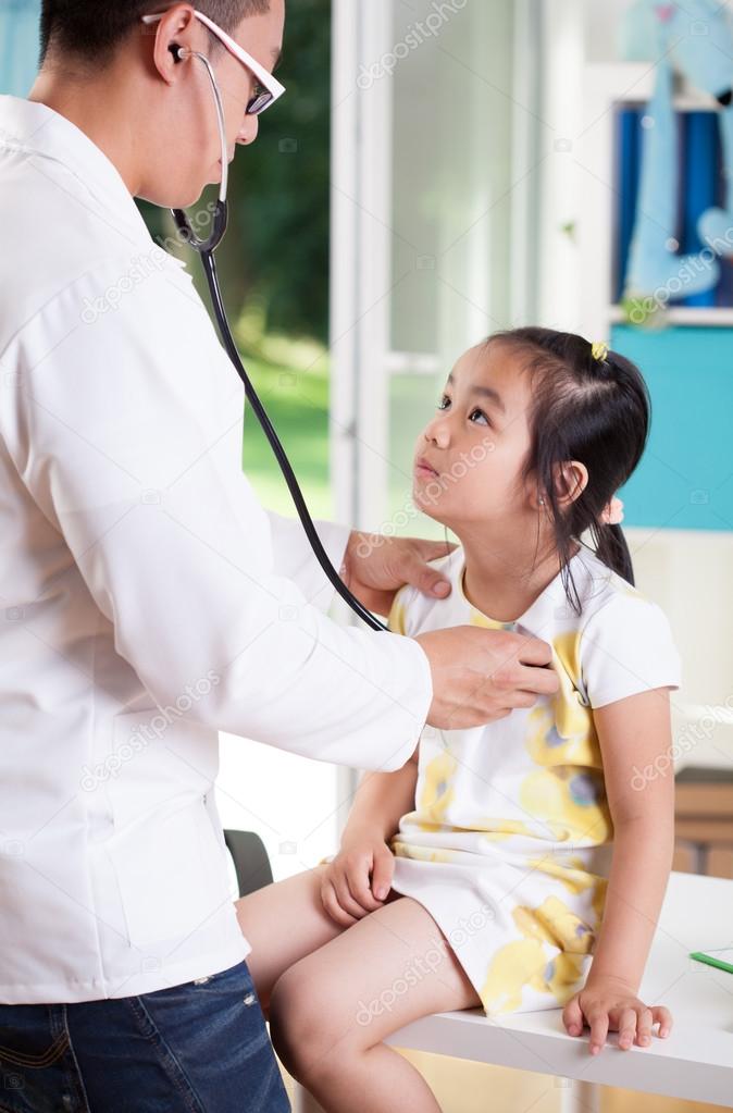 Asian doctor examining girl