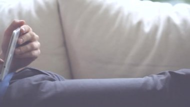 adam kanepede yatan ve tablet üzerinde oynama